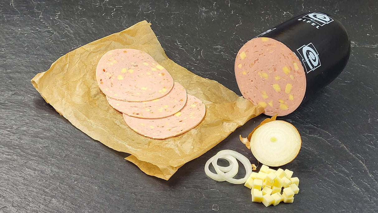 Lyoner Cheese und Onions vom EIFEL Schwein auf Backpapier aufgeschnitten angerichtet mit Zwiebel und Käse auf Schieferhintergrund