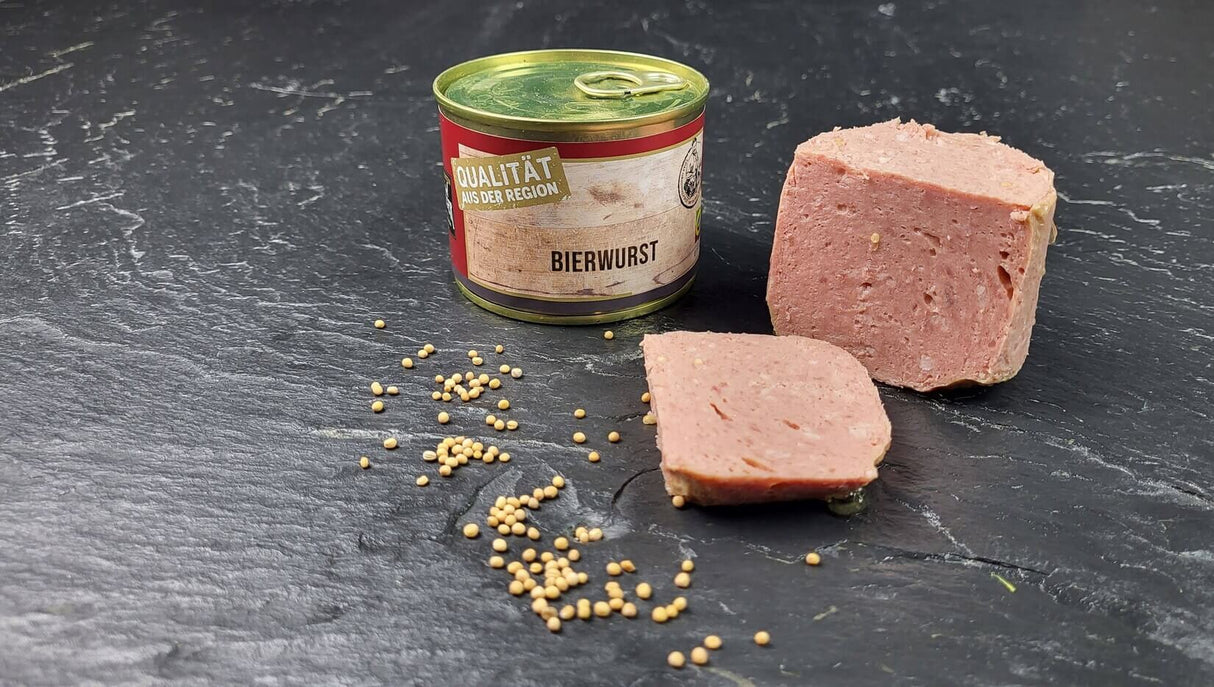 Bierwurst vom EIFEL Schwein angerichtet mit Senfkörnern auf Schieferhintergrund