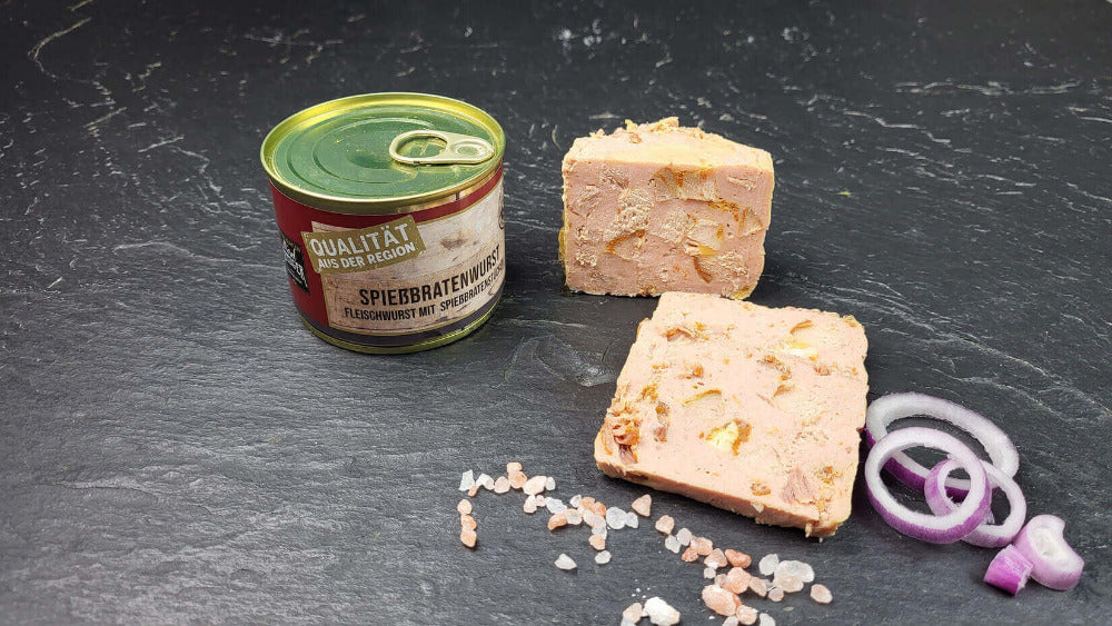 Spießbratenwurst vom EIFEL Schwein angerichtet mit Zwiebeln auf Schieferhintergrund