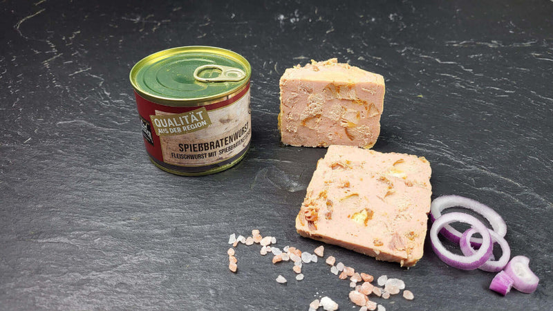 Spießbratenwurst vom EIFEL Schwein angerichtet mit Zwiebeln auf Schieferhintergrund