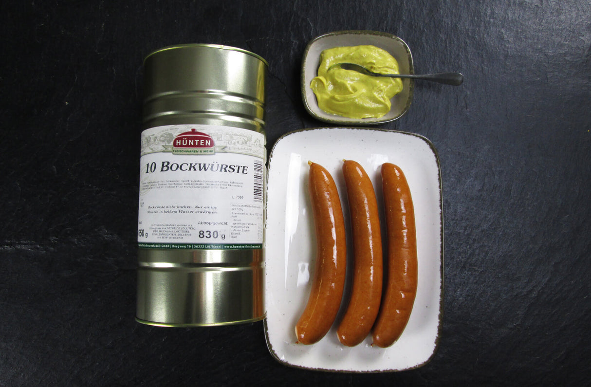 10 Bockwürste auf Teller mit einer Schale Senf auf Schieferhintergrund