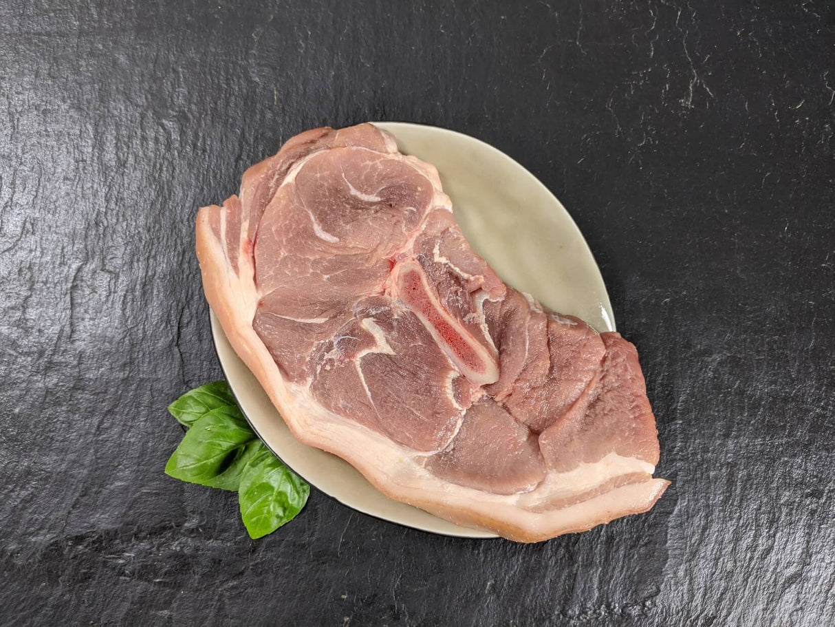 Holzfällersteak auf Teller mit Kräutern auf Schieferhintergrund