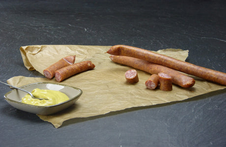 Schinkenmettwurst vom EIFEL Schwein mit Senf auf Schieferhintergund