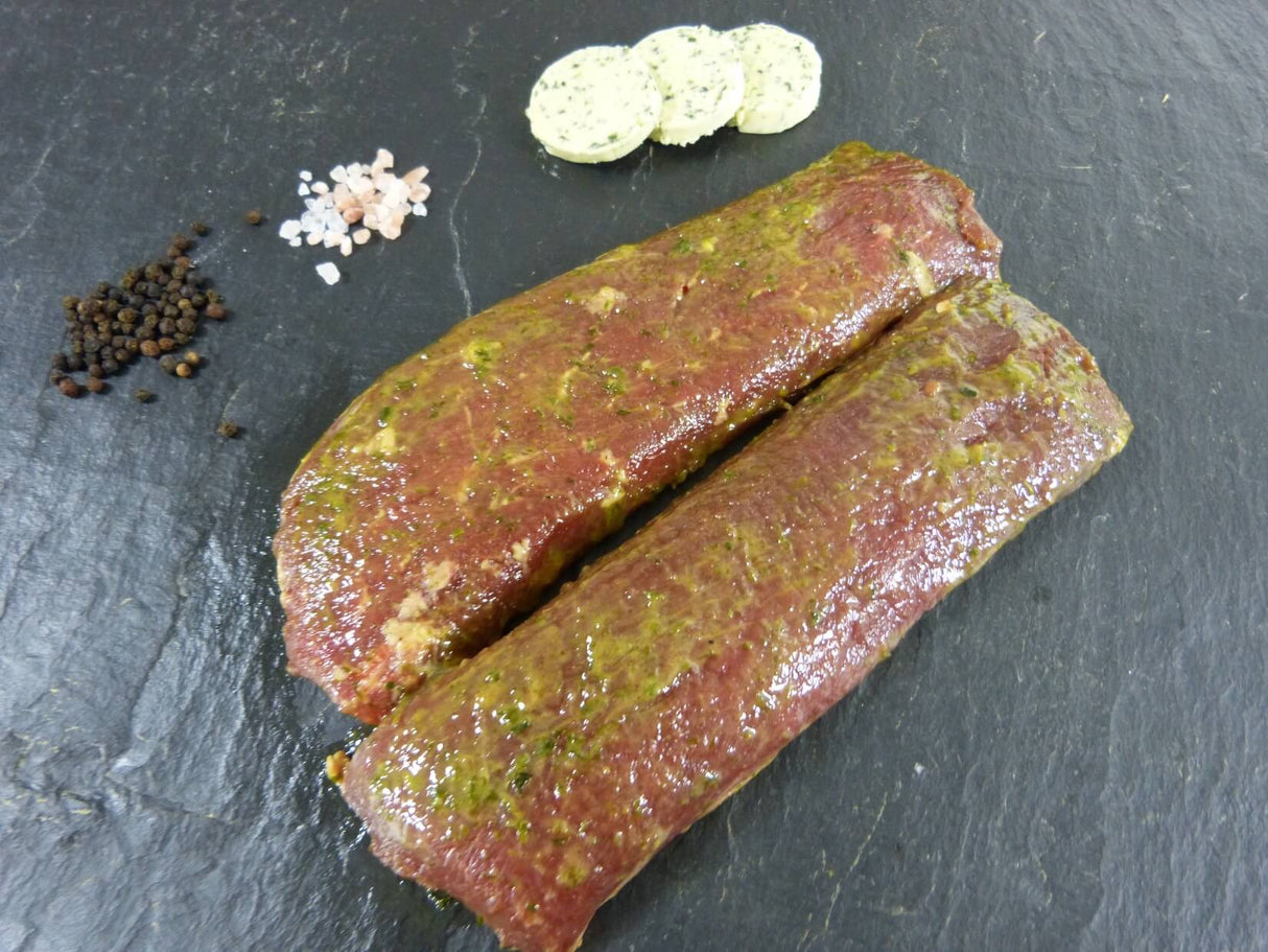 Lammlachs Kräuter Knoblauch auf Schieferhintergrund angerichtet mit groben Salz und Pfefferkörnern und Kräuterbutter auf Schieferhintergrund