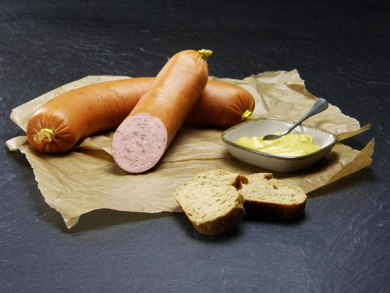 Krakauer 2 halbe Ringe vom EIFEL Schwein mit Scheiben Brot und eine Schüssel Senf auf Schieferhintergrund