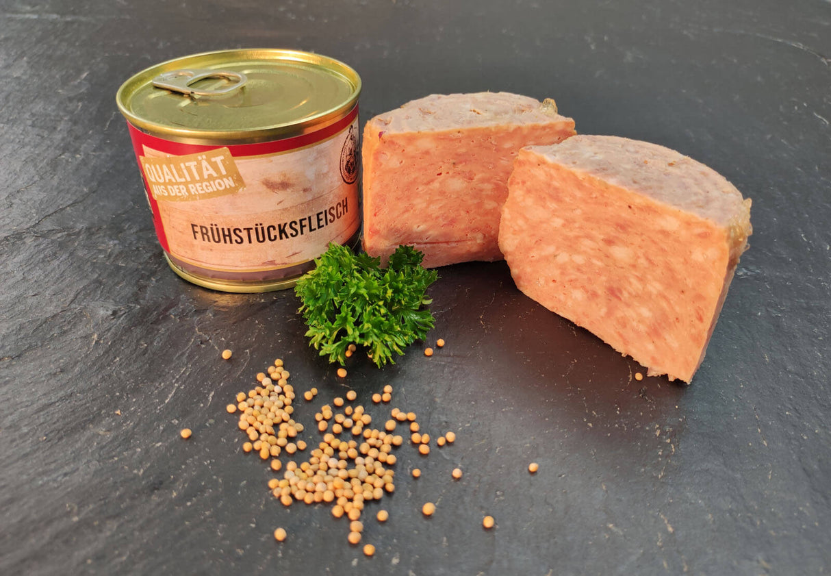 Frühstücksfleisch vom EIFEL Schwein angerichtet mit Petersilie und Senfkörnern auf Schieferhintergrund