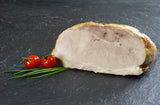 Schweinegrillbraten Aufschnitt am Stück mit Schnittlauch und Tomaten auf Schieferhintergrund
