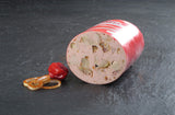 Eine halbe Spießbratenwurst vom EIFEL Schwein angerichtet mit einer kleinen Paprika und paar Zwiebelringen mit Paprika gewürz drauf auf Schieferhintergrund