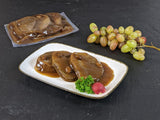 Sauerbraten Rheinischer Art im Kochbeutel und gegart auf Teller mit Trauben dekoriert auf Schieferhintergrund
