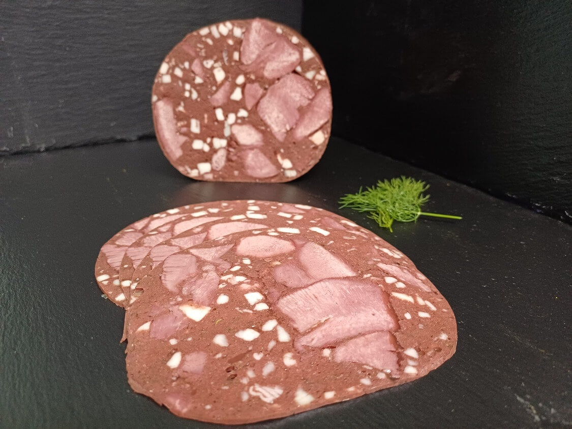 Blutzungenwurst am Stück und geschnitten dekoriert mit Thymian 