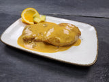 Hähnchenbrustfilets in Orangen Mango Sauce auf Teller auf Schieferhintergund