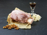 Schweinshaxe gepökelt und gegart mit Sauerkraut und Salzbretzeln auf Schieferhintergrund