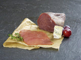 Rinder Rauchfleisch etwas  in Scheiben aufgeschnitten mit Blauschimmelkäse und Trauben auf Schieferhintergrund