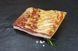 Dörrfleisch trocken gesalzen mit grobem Salz und Rosmarin auf Schieferhintergrund
