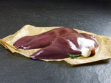Schweine Leber am Stück mit Zwiebeln und Thymian auf Schieferhintergrund