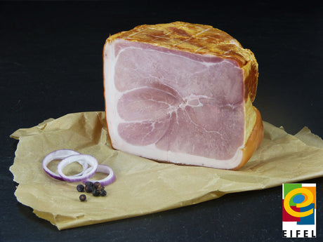 Metzgerschinken vom EIFEL Schwein mit roten Zwiebeln und Wachholderbeeren mit Ähren auf Schieferhintergrund