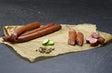 Pfeffer Schinkenmettwurst vom EIFEL Schwein mit Pfefferkörner und Gurke auf Schieferhintergrund