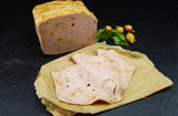 Zwiebelfleischkäse gebacken geschnitten vom EIFEL Schwein mit Petersilie und Zwiebeln auf Schieferhintergrund