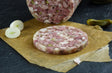 Schweinskopfsülze mit Gurken Riegel mit einer Zwiebel und einer Gewürzgurke auf Schieferhintergrund