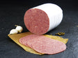 Deutsches Cornedbeef geschnitten mit Knoblauch und Pefferkörner auf Schieferhintergrund