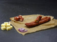 Käse Schinkenmettwurst vom EIFEL Schwein mit Käsewürfeln und Zwiebeln auf Schieferhintergrund