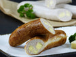 Käsebratwurst vom EIFEL Schwein mit Petersilie und Käsewürfeln auf Schieferhintergrund