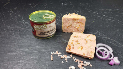 Spießbratenwurst vom EIFEL Schwein angerichtet mit Zwiebeln auf Schieferhintergrund
