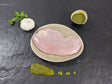 Putensteak Natur auf Teller angerichtet mit einer Schale Kräuter Knoblauch Marinade mit Petersilie einer Knoblauchzehe auf Schieferhintergrund