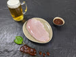 Putensteak Braumeister auf Teller angerichtet mit einer Schale Braumeister Marinade einem Glas Bier und Kräutern auf Schieferhintergrund