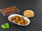 Currywurst in der Schale mit Brötchen auf Schieferhintergrund
