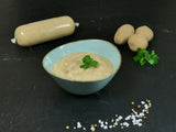 Kartoffelsuppe in Schale angerichtet mit Petersilie und Kartoffeln auf Schieferhintergrund