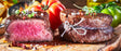 Jungbullen Filetsteaks vom EIFEL Rind auf Holzbrett angerichtet mit Tomaten Gewürzen und Chilischoten