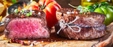 Jungbullen Filetsteaks vom EIFEL Rind auf Holzbrett angerichtet mit Tomaten Gewürzen und Chilischoten
